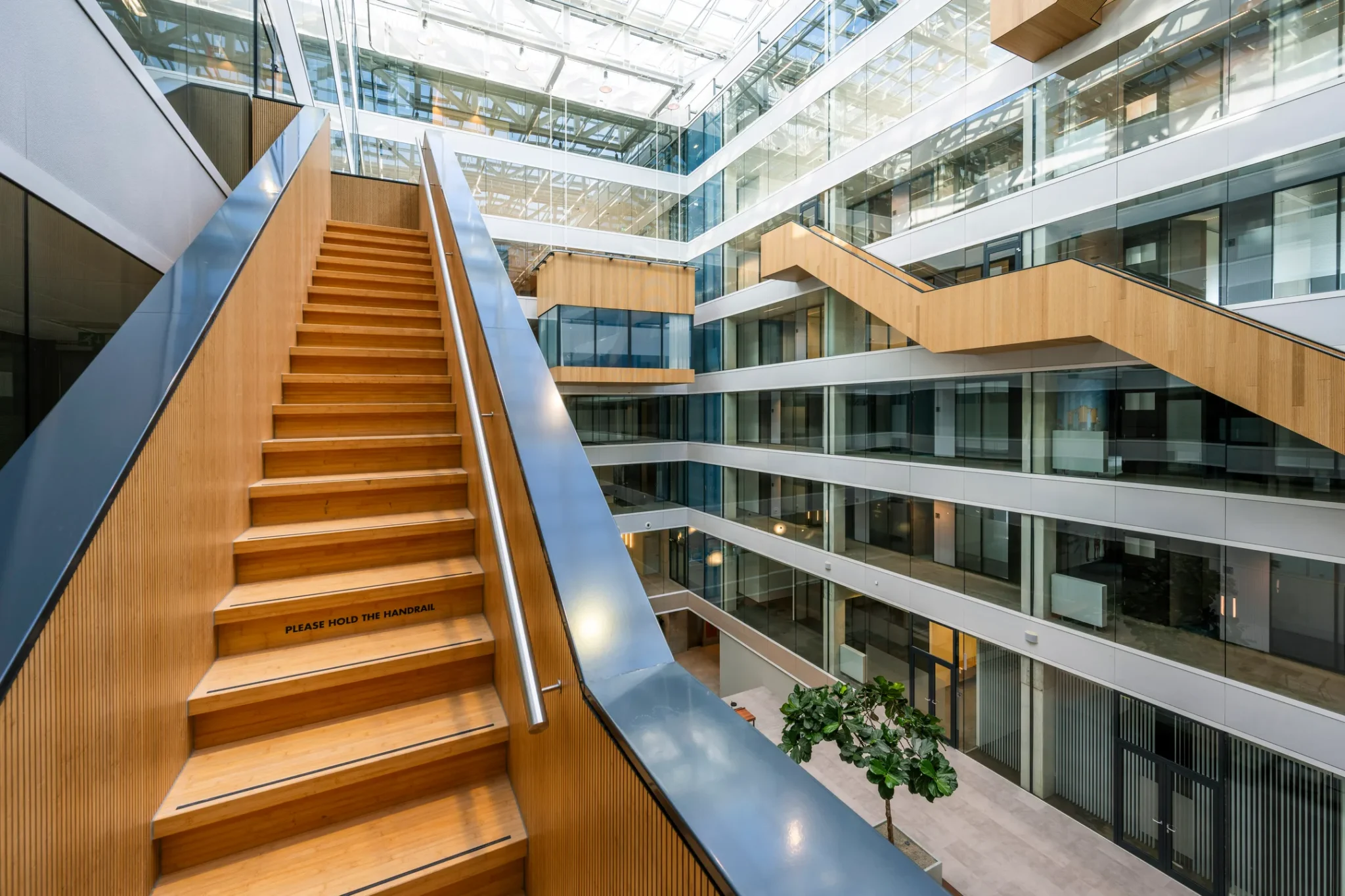Houten trap met metalen leuningen in een modern, licht atrium van kantoorgebouw 505_2160.