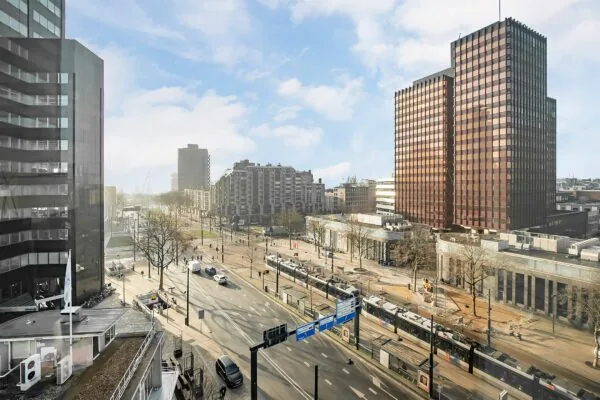 Stadszicht op de Coolsingel in Rotterdam met trams, verkeer en hoge kantoorgebouwen, waaronder het opvallende bruine gebouw 566_2160.