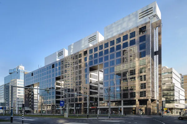 Een modern kantoorgebouw aan het Weena in het stadscentrum, met een strakke glazen gevel en heldere lucht op de achtergrond.