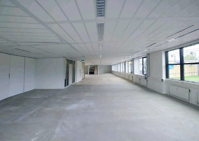 Leegstaand kantoorpand aan het Stationsplein met grote ramen en systeemplafond.