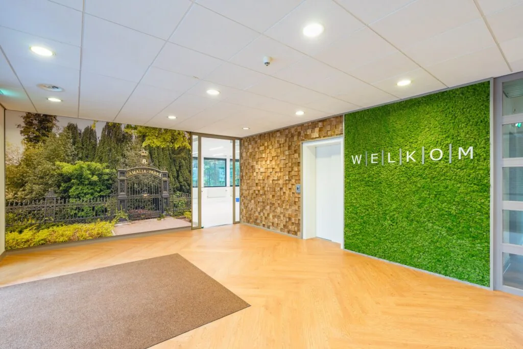 Entree met een fotowand van Amalia Park en een groene muur met het woord "Welkom".