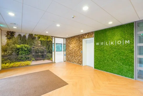 Entree met een fotowand van Amalia Park en een groene muur met het woord "Welkom".