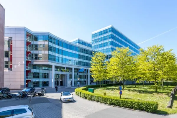 Modern kantoorgebouw aan de Newtonlaan met een glazen gevel en omliggend groen.