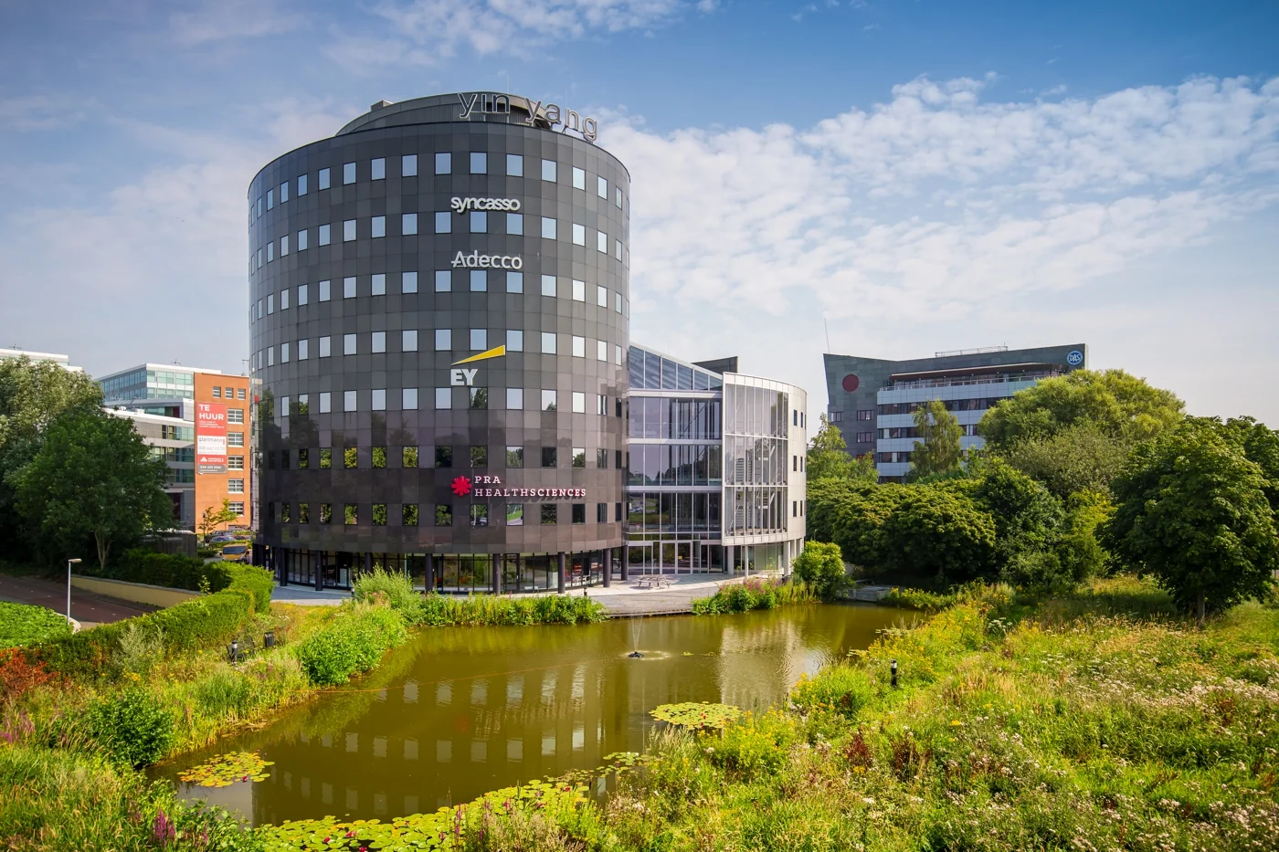 Een modern kantoorgebouw aan de Euclideslaan, omgeven door een vijver en groen.