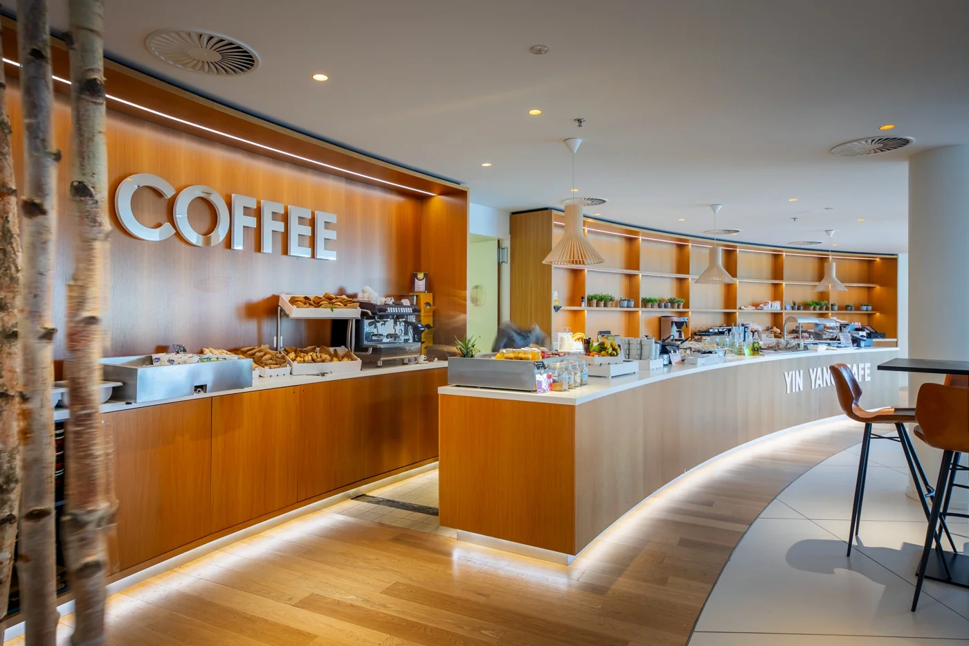 Een moderne koffiebar genaamd "Yin Yang Cafe" met een uitgebreide selectie aan broodjes en drankjes.