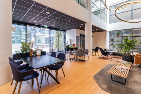 Een moderne en uitnodigende kantoorruimte met zitgedeelten en veel planten.