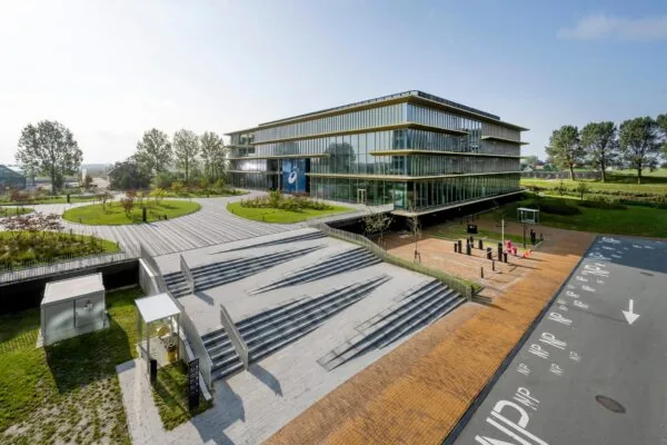 Modern kantoorgebouw aan de Taurusavenue met glazen gevel, ruime trappartij en groene omgeving.