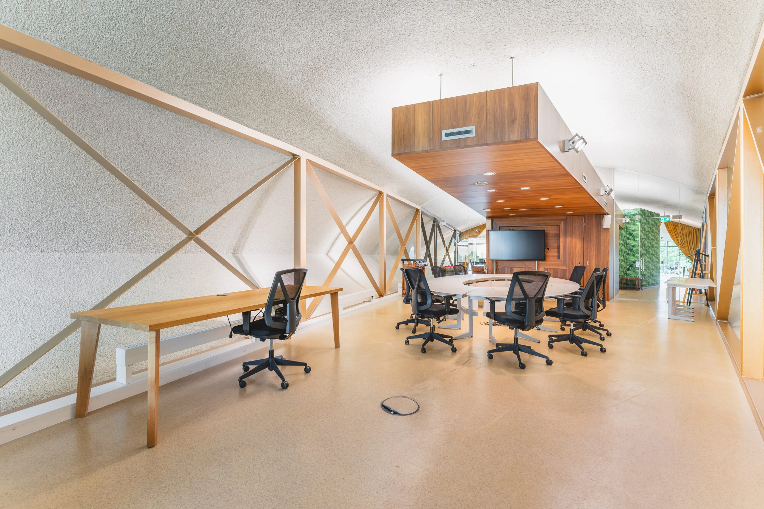 Moderne en ruime vergaderruimte met houten elementen en bureaustoelen.