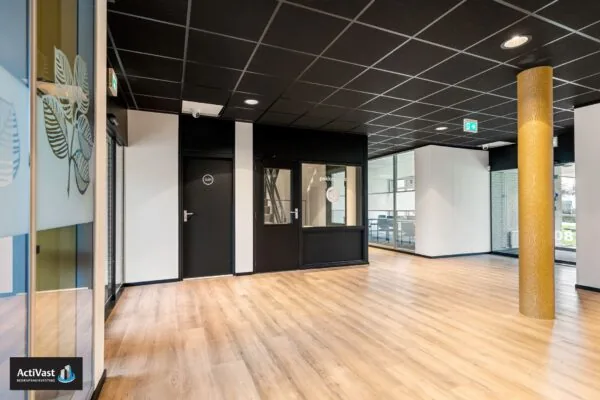 Moderne kantoorruimte in Agro Business Park 22_3 met houten vloer, zwarte plafonds en glazen wanden.