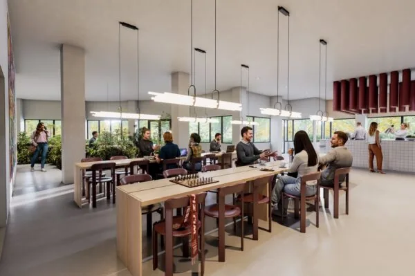 Moderne gemeenschappelijke ruimte met mensen die werken, praten en ontspannen aan lange tafels en bij het koffie-uitgiftepunt.