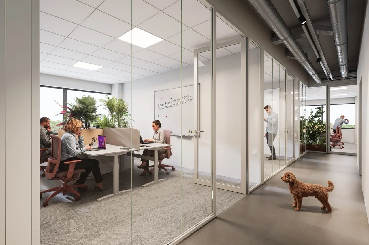 Een modern kantoor met glazen wanden, waar mensen werken en een hond rondloopt, omringd door planten.