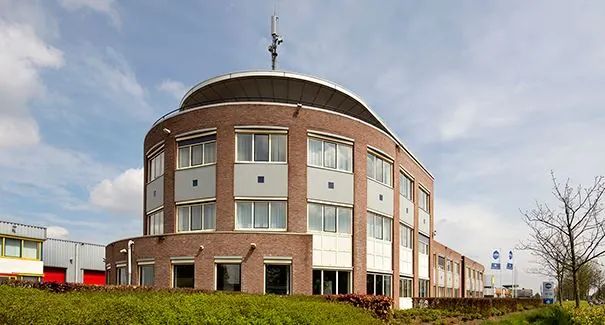 Modern kantoorgebouw aan de Dr. Nolenslaan 157 met ronde gevel en bakstenen buitenkant.