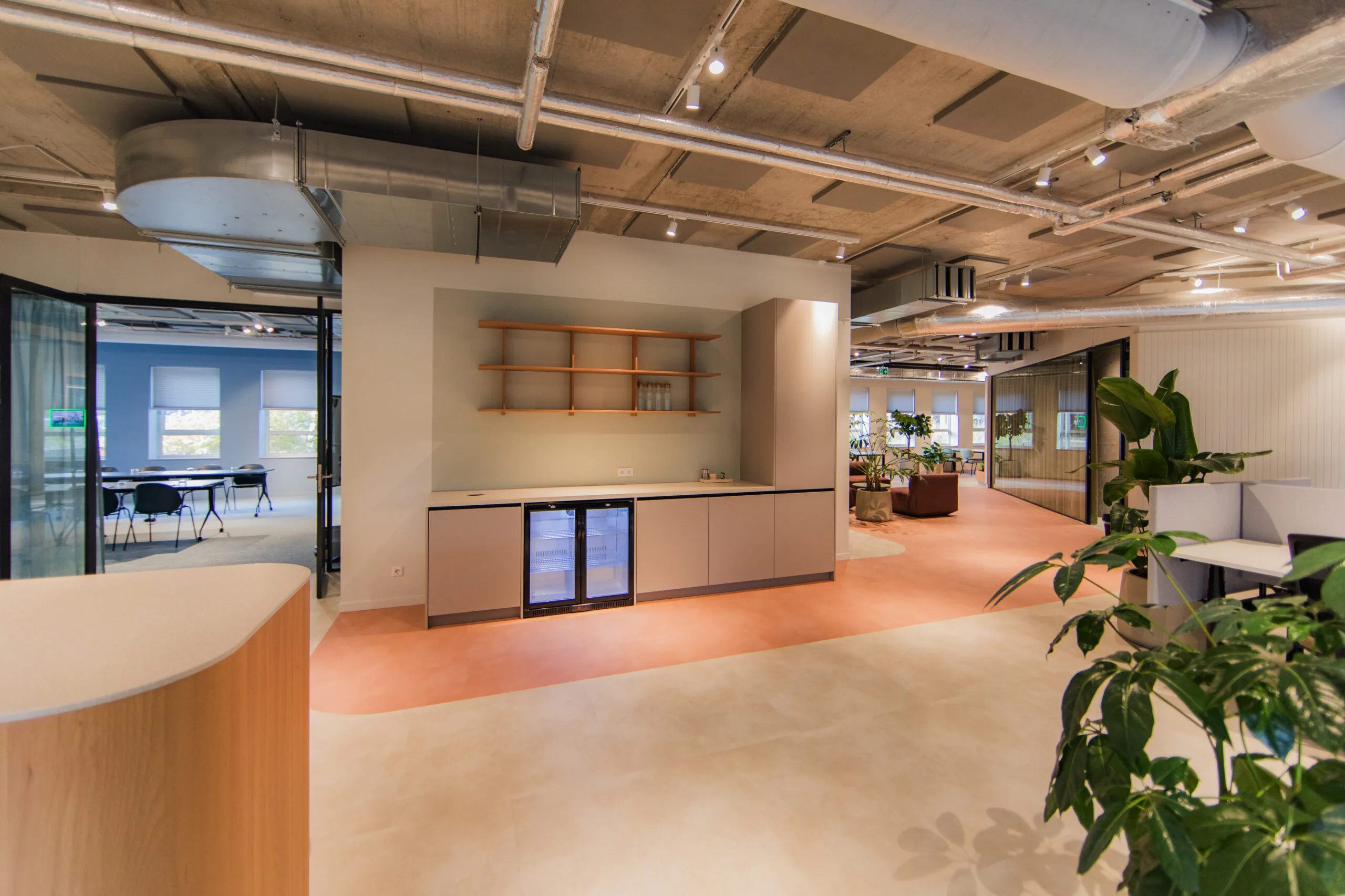 Modern office interior at Hullenberg with an open kitchenette, lounge area, and visible meeting room.