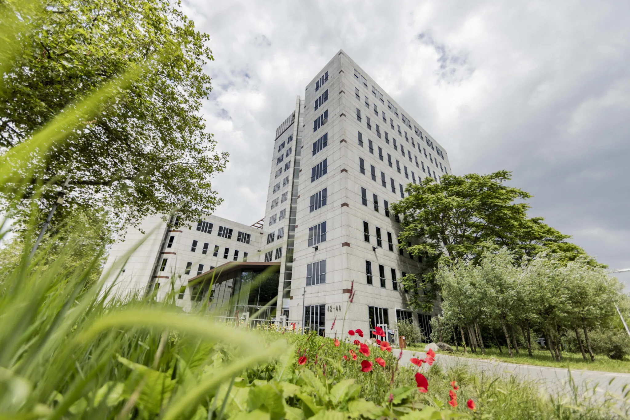 Kantoorgebouw EO in Diemen omringd door groen en bloemen, gefotografeerd vanuit een laag standpunt.