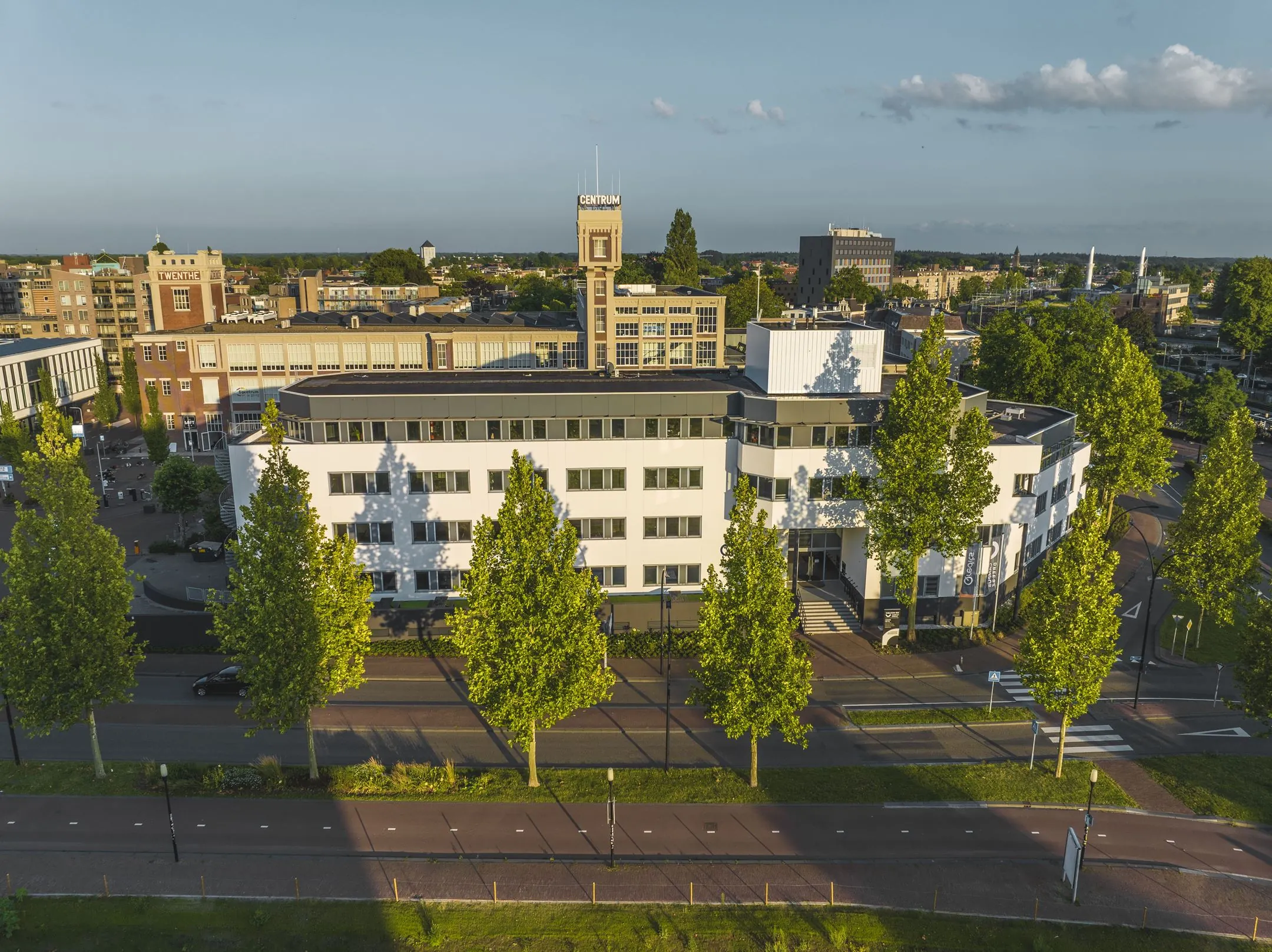 Wit kantoorgebouw aan de Egbert Gorterstraat 2-14 in Enschede, omgeven door groene bomen en stadsbebouwing.