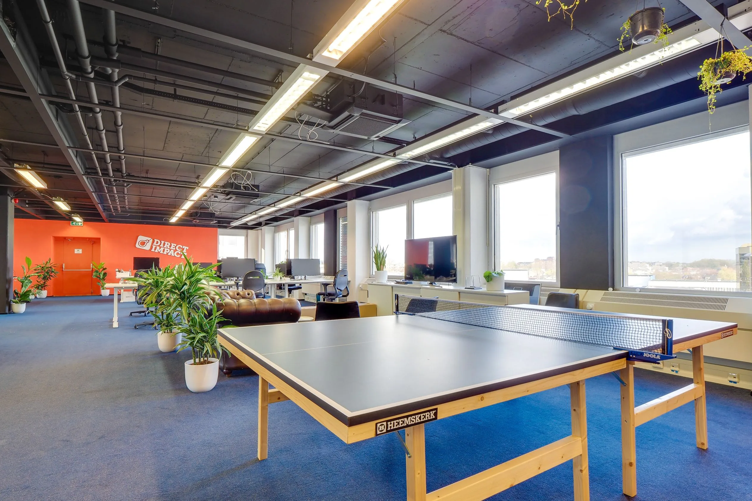 Modern kantoorinterieur aan de Europalaan 400 met werkplekken, een tafeltennistafel en veel natuurlijke lichtinval.