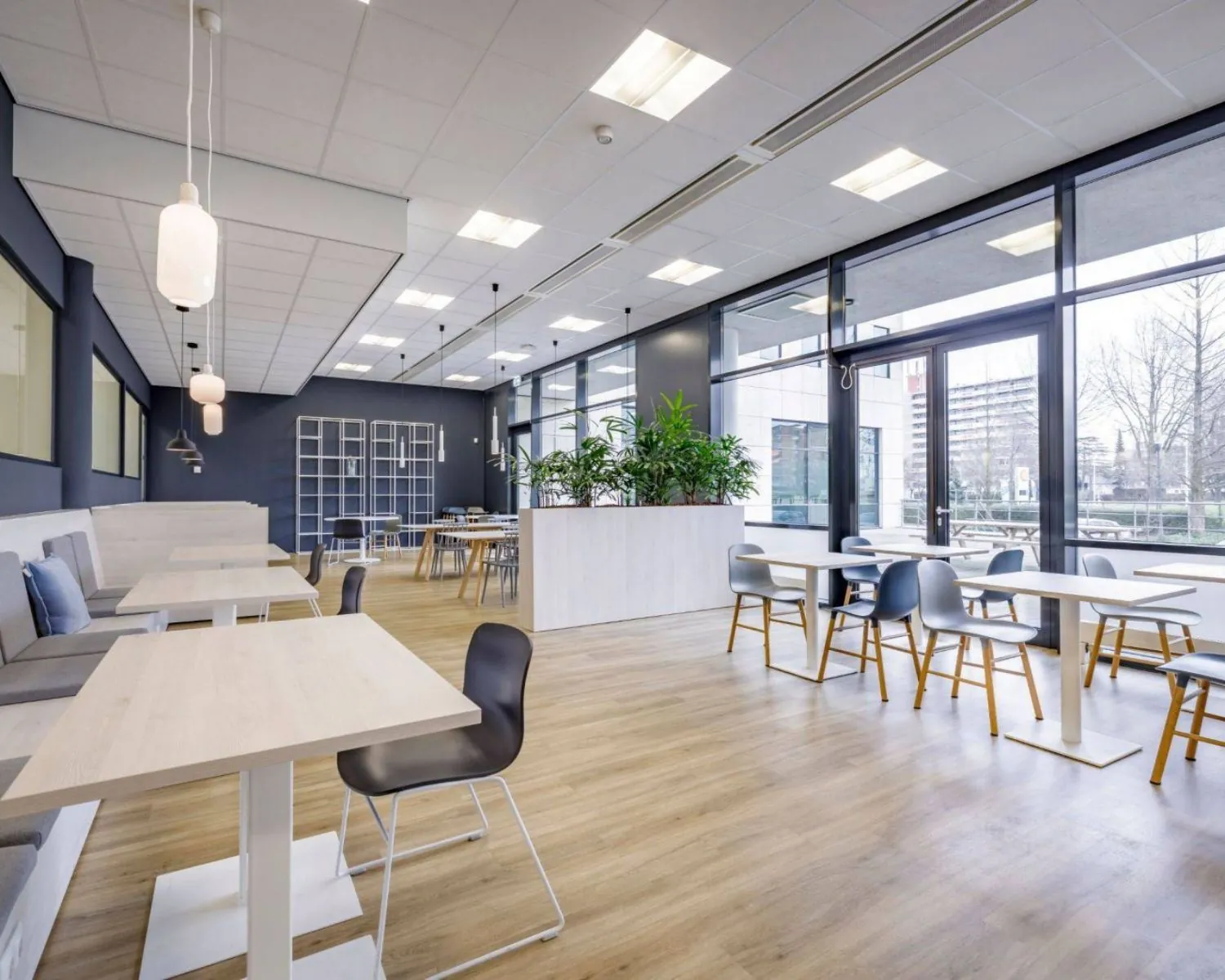 Moderne kantoorlounge met veel daglicht, houten vloer en zitgelegenheid aan de Anderlechtstraat 15.