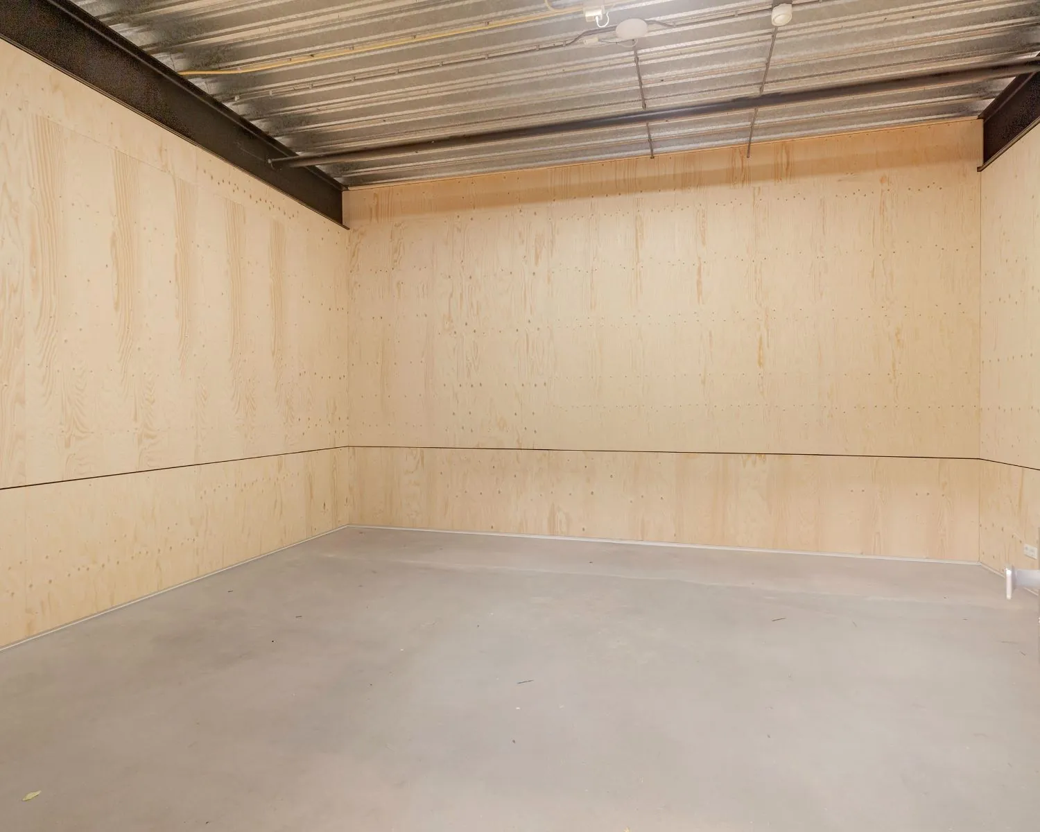 Lege kantoorruimte met houten wanden, betonnen vloer en een plafond van metalen balken in Hoofdveste 2, Houten.
