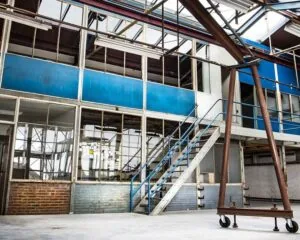 Industriële kantoorruimte te huur aan het Kalkhovenplein 3b in Halfweg met een metalen trap en grote ramen.