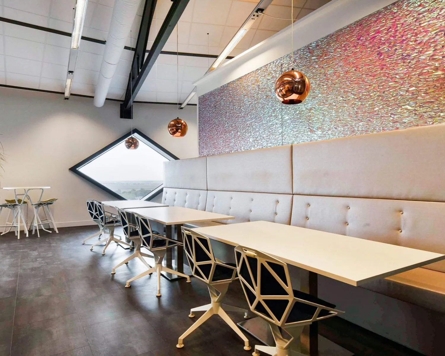 Moderne kantoorruimte in SugarCity Halfweg met strakke inrichting, designstoelen en opvallende wanddecoratie.