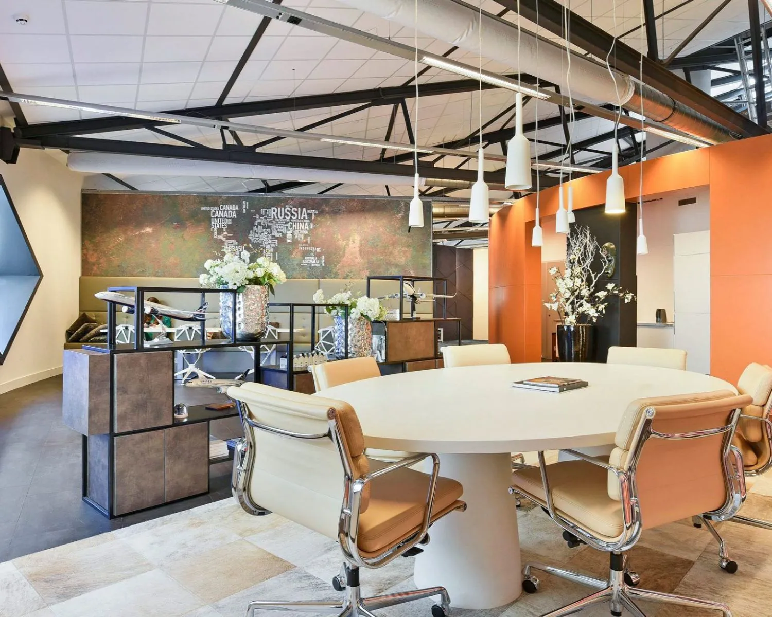 Moderne kantoorruimte in SugarCity Halfweg met een ronde vergadertafel, designstoelen en industriële accenten.