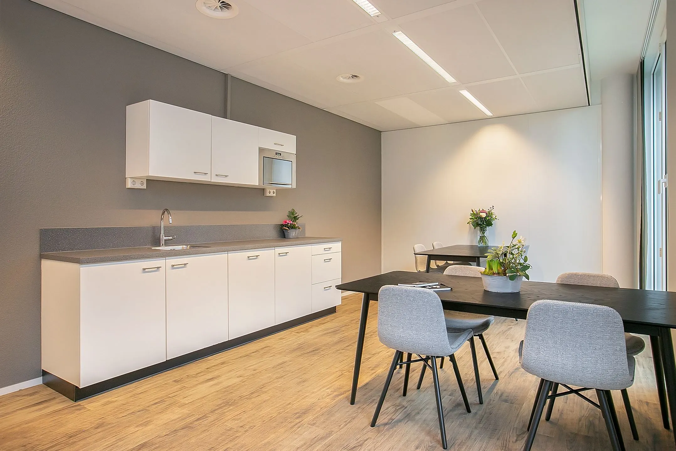 Moderne pantry en zithoek in een kantoorruimte aan de Cuserstraat 91 in Amsterdam.
