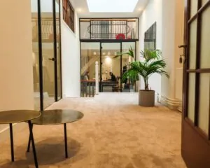 Moderne kantoorruimte aan de Herengracht 449a in Amsterdam met glazen deuren, een zithoek en uitzicht op een vergaderruimte.