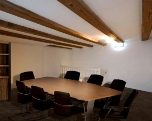Vergaderruimte met houten balkenplafond en vergadertafel met acht stoelen in een kantoor aan de Herengracht 449a in Amsterdam.