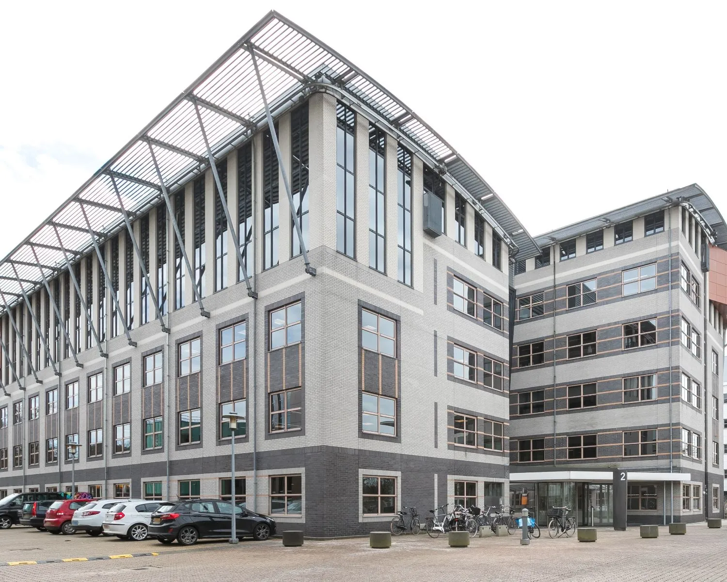 Moderne kantoorruimte aan de Olympia 2d-8 in Hilversum met parkeerplaatsen en fietsenstalling voor de ingang.