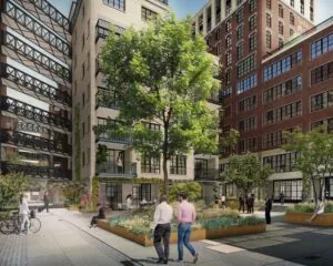 Binnenplaats van een modern kantoorgebouw aan de Karl Weisbardstraat in Rotterdam met groene beplanting en mensen in gesprek.