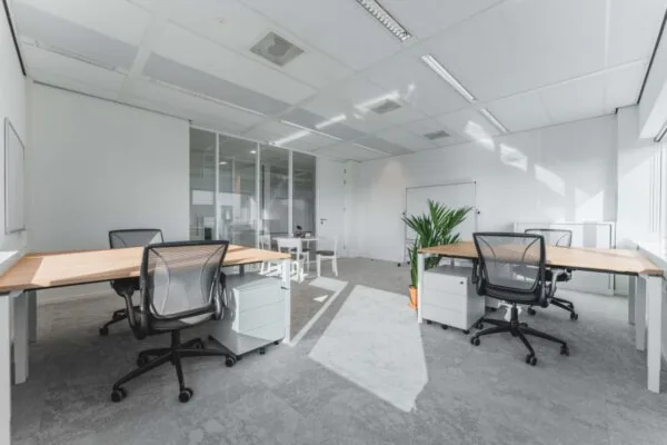 Een moderne, lichte kantoorruimte met bureaus en stoelen op de Barbara Strozzilaan 101 in Amsterdam.