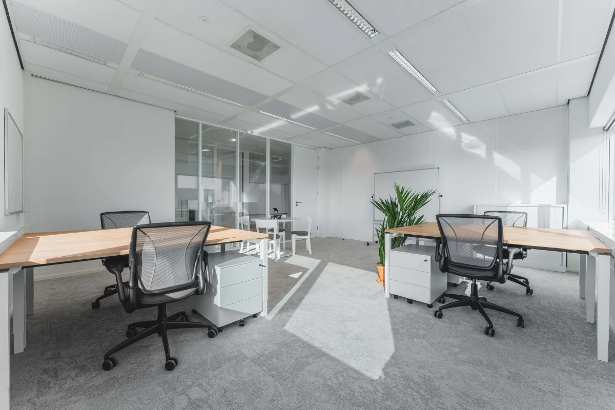 Een moderne, lichte kantoorruimte met bureaus en stoelen op de Barbara Strozzilaan 101 in Amsterdam.