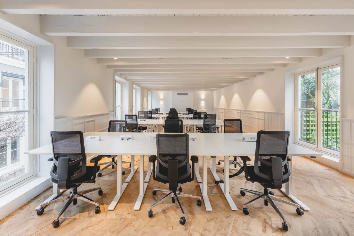 Moderne kantoorruimte met bureaus en stoelen aan de Keizersgracht 125-127 in Amsterdam.