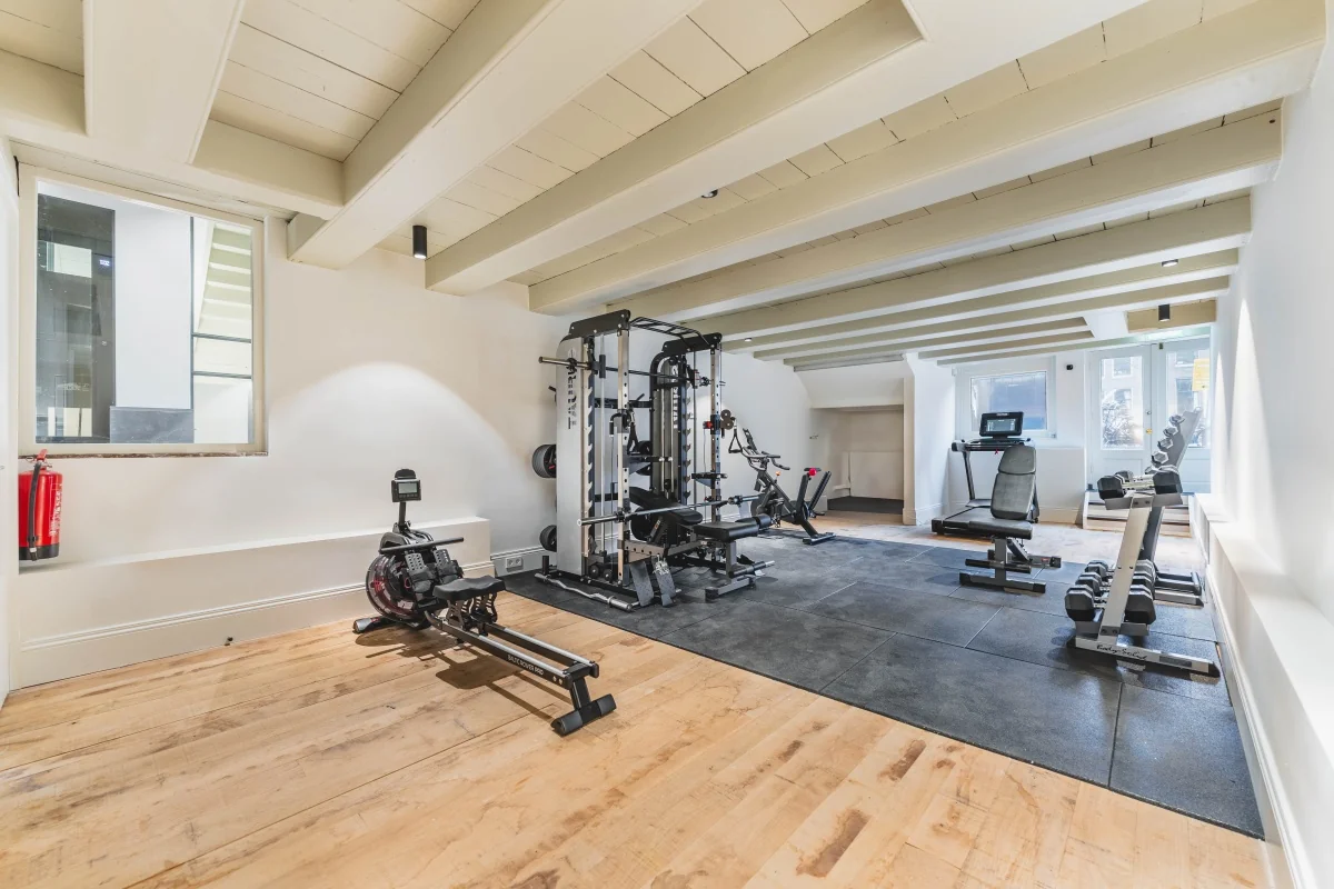 Lichte fitnessruimte met verschillende trainingsapparaten op de Keizersgracht 125-127 in Amsterdam.