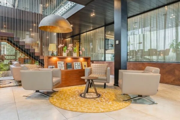Moderne kantoorruimte in Amsterdam met stijlvolle zitstoelen en een opvallende gele vloerkleed.