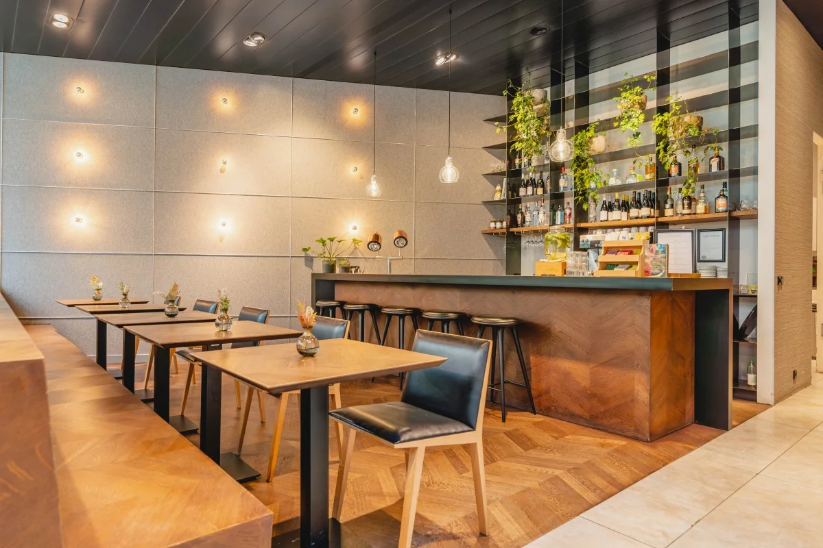 Een moderne kantoorruimte met een stijlvolle bar en tafels, gelegen aan de Muiderstraat in Amsterdam.