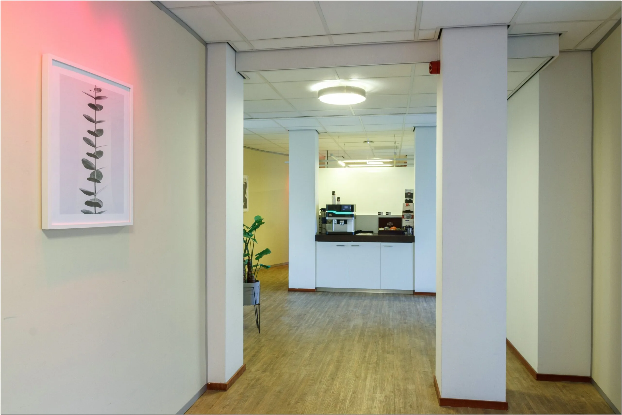 Koffiecorner in een moderne kantoorruimte aan de Bredewater 26 in Zoetermeer met houten vloer en minimalistische inrichting.