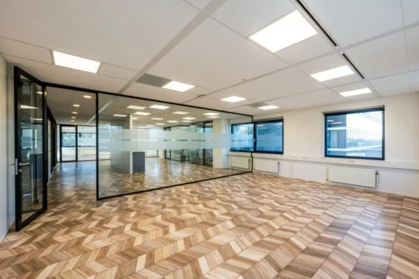 Lichte en ruime kantoorruimte met moderne glazen wanden en houten vloer op Overscheistraat 59 in Amsterdam.