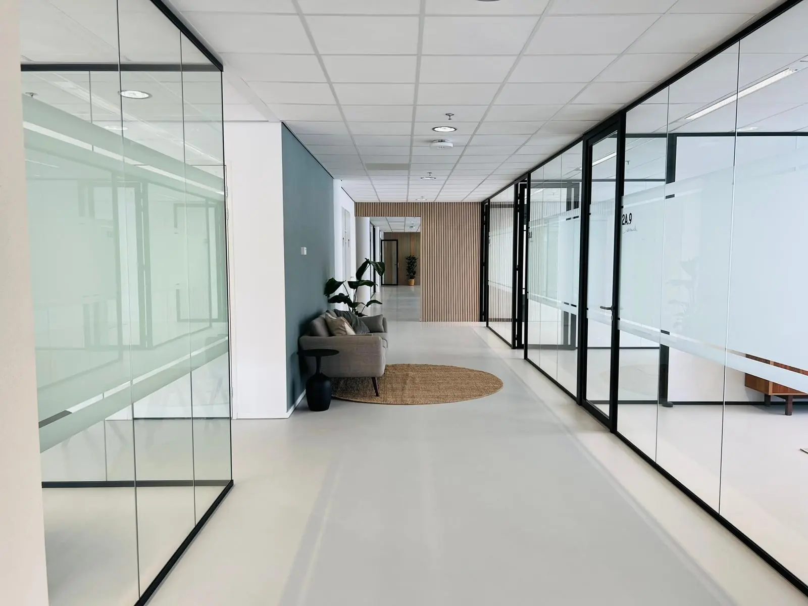 Moderne kantoorruimte aan het Kruisplein 480 in Rotterdam met glazen wanden en een loungehoek.