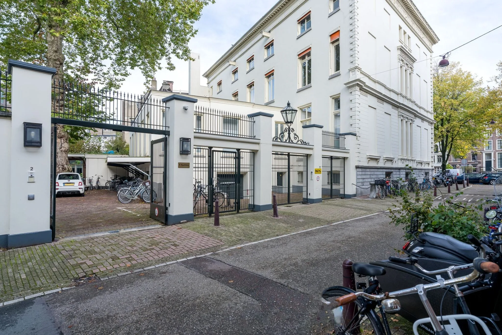 Ingang met hekwerk en fietsenstalling van het witte pand aan Keizersgracht 452 in Amsterdam.