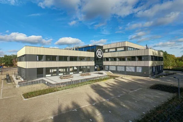 Modern kantoorgebouw aan de Laapvelderweg 15 met ruime parkeerplaats en zonnig terras.