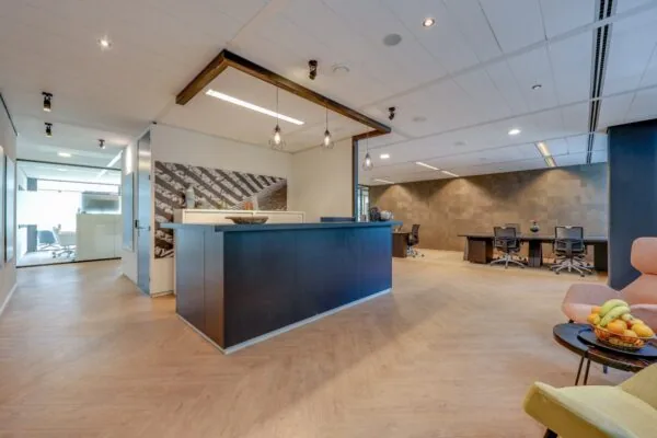 Ontvangstruimte van Tribes Amsterdam met een moderne balie en zitgelegenheid.
