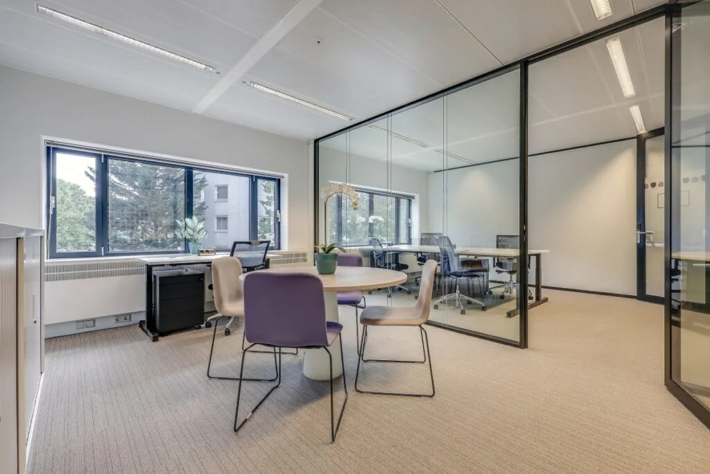 Privékantoor in Tribes Amsterdam Amstel met glazen wanden, moderne meubels en veel natuurlijk licht.