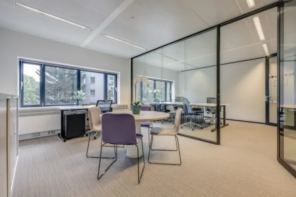 Privékantoor in Tribes Amsterdam Amstel met glazen wanden, moderne meubels en veel natuurlijk licht.