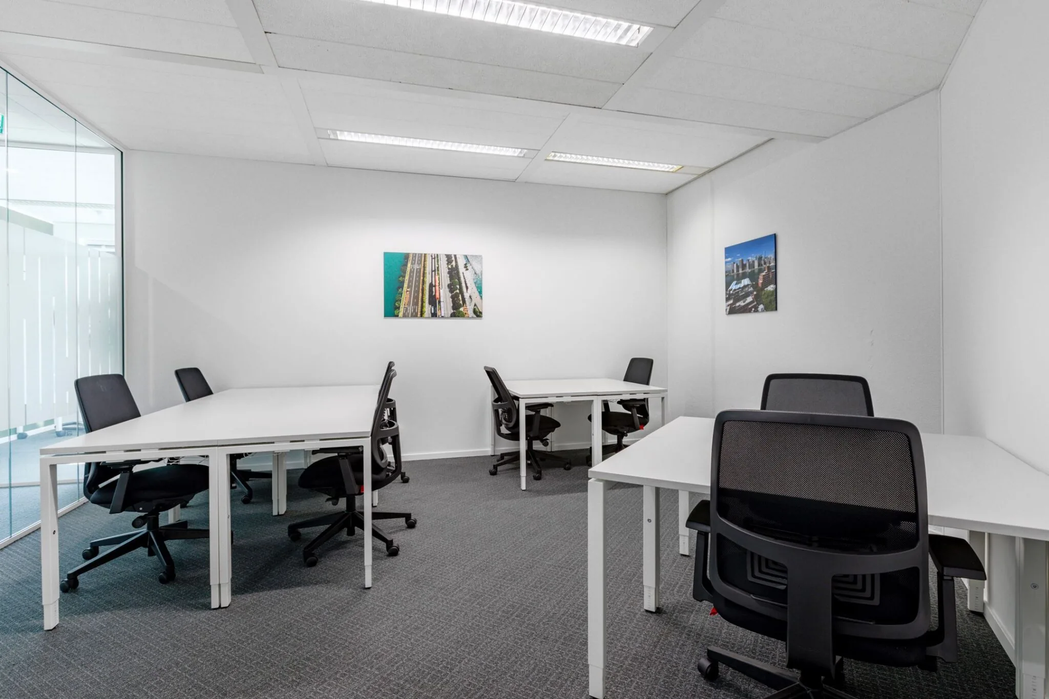 Kantoorruimte met zes bureaus en bureaustoelen in een lichte, moderne inrichting aan Nevelgaarde 8.