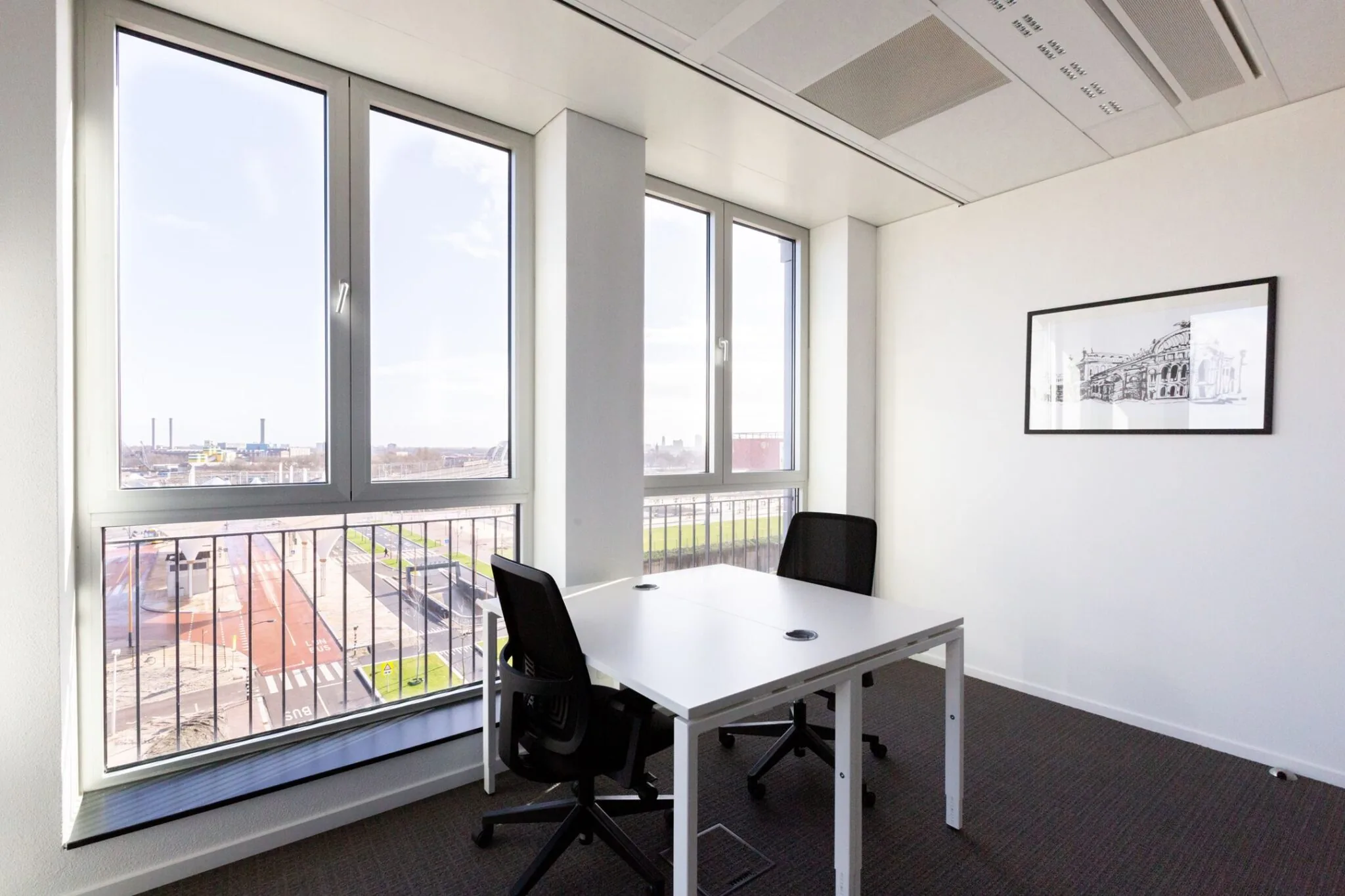 Licht en modern kantoor met twee bureaustoelen en uitzicht op Parijsboulevard.