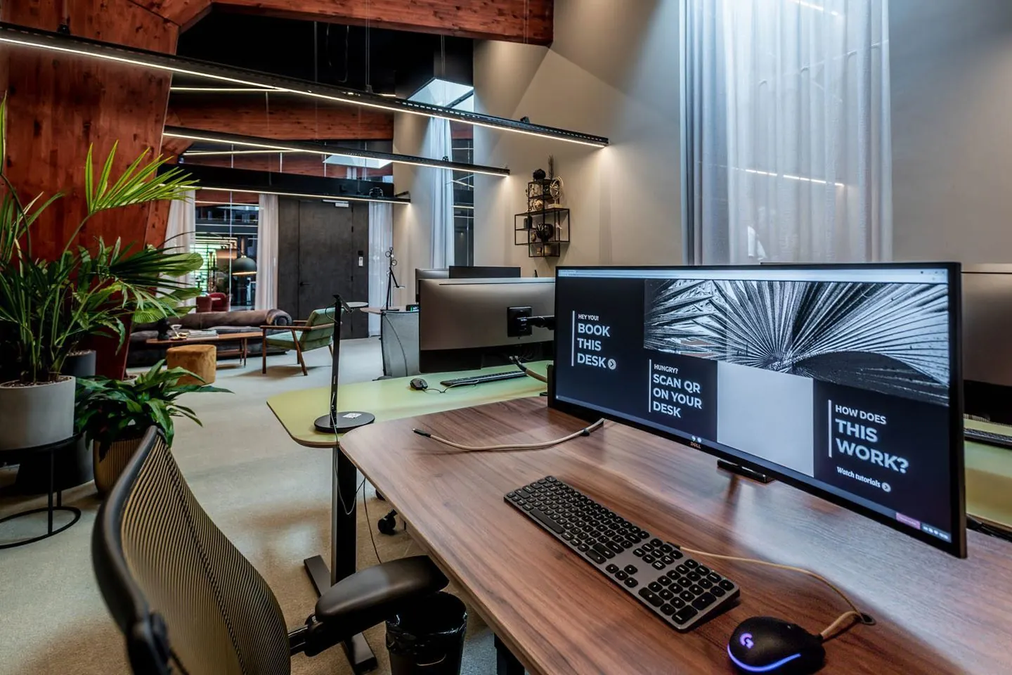 Moderne flexwerkplek met houten afwerking en groot beeldscherm in een stijlvol kantoor aan de Plaatweg 15.