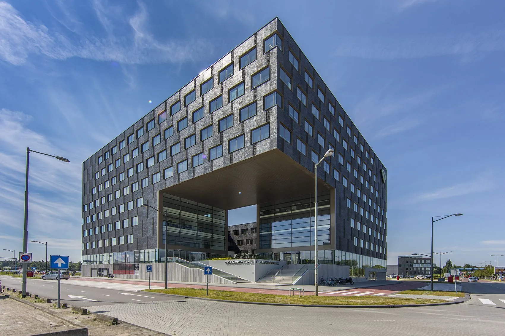Modern kantoorgebouw aan het Rotterdam Airportplein 22 met opvallende rechthoekige doorgang in het midden.