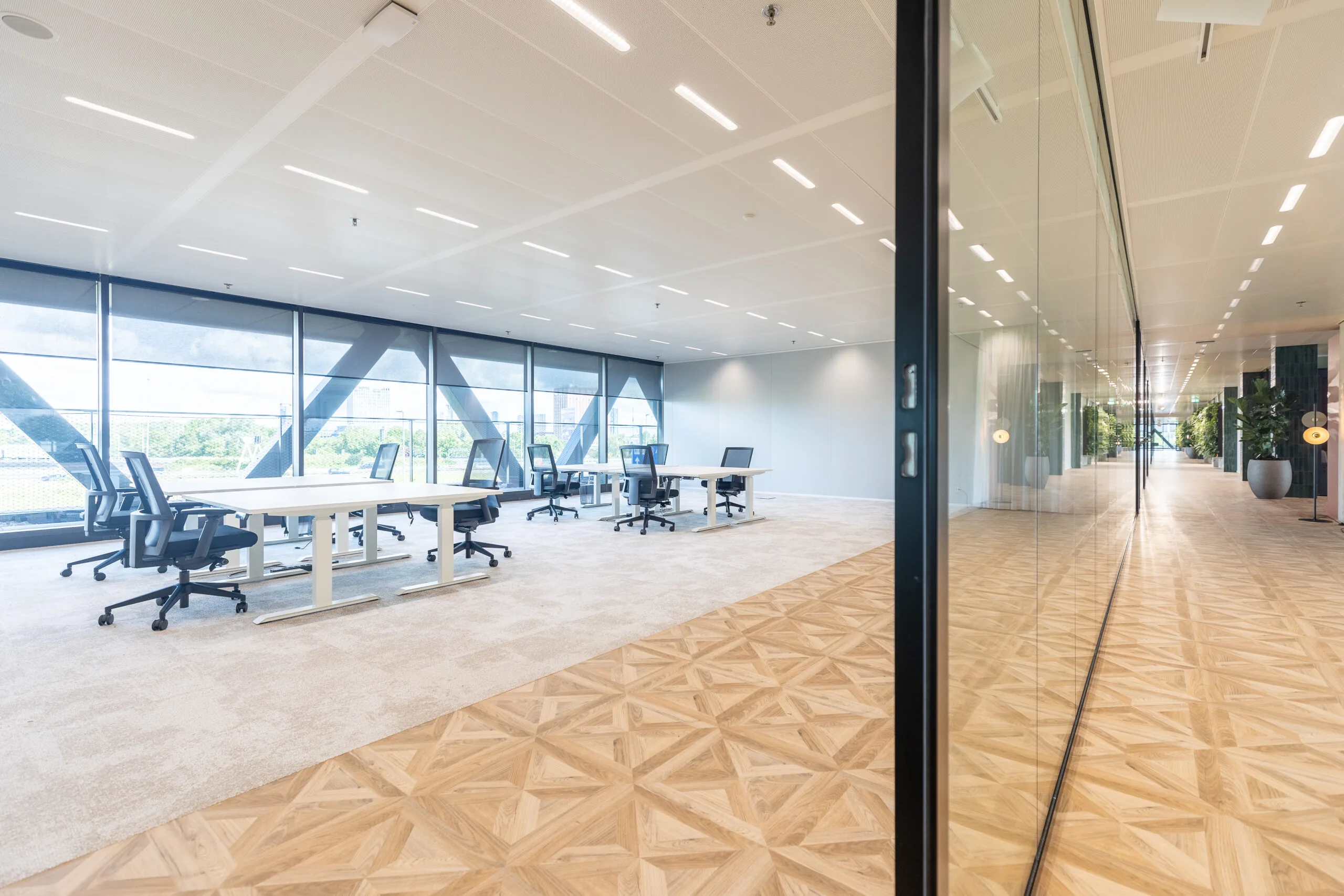 Modern en licht kantoorinterieur in The Joan-30 met ruime werkplekken, glazen wanden en uitzicht op de stad.
