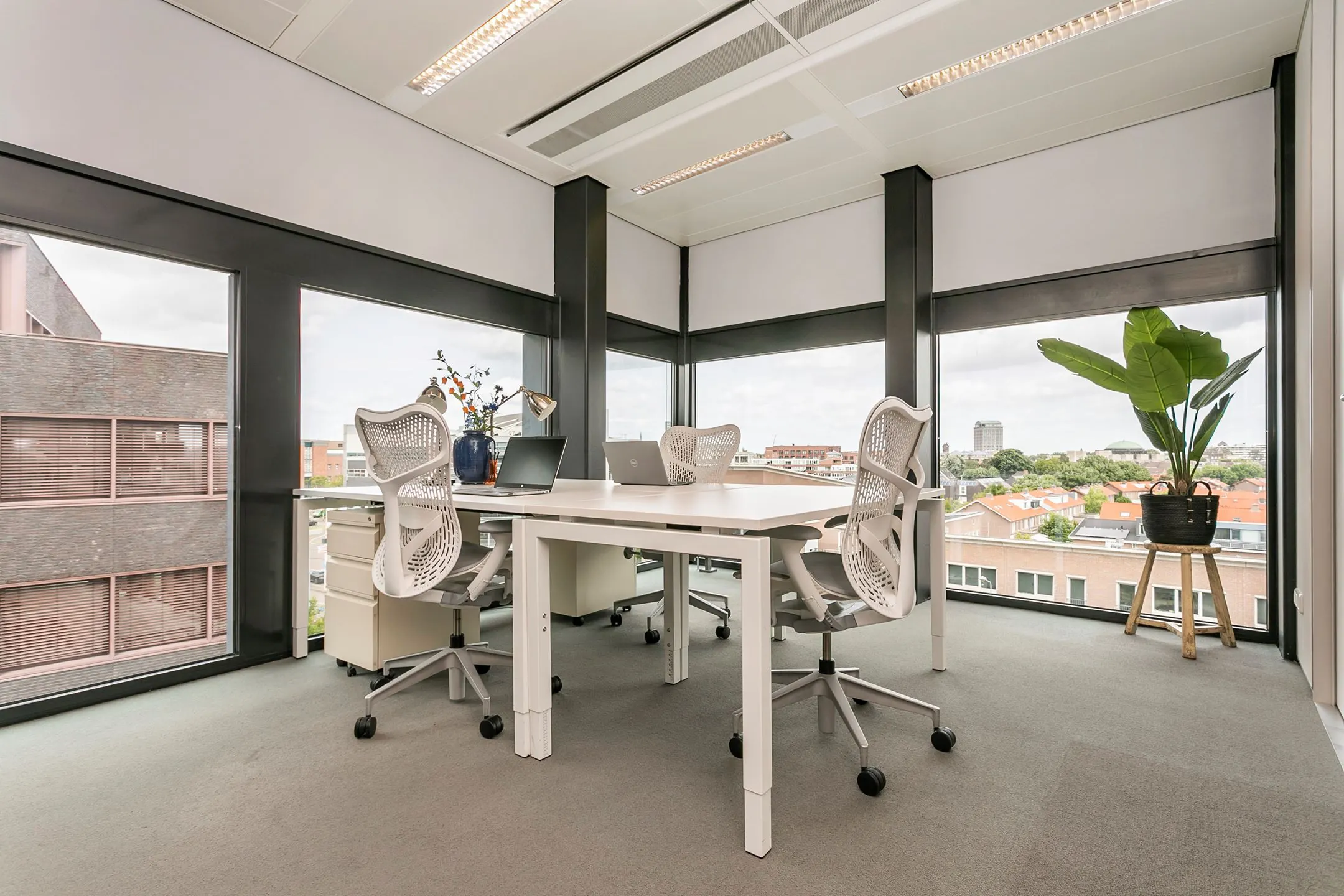 Modern ingericht kantoor op een hoeklocatie met grote ramen en uitzicht over de stad vanaf het Wim Duisenbergplantsoen 31.